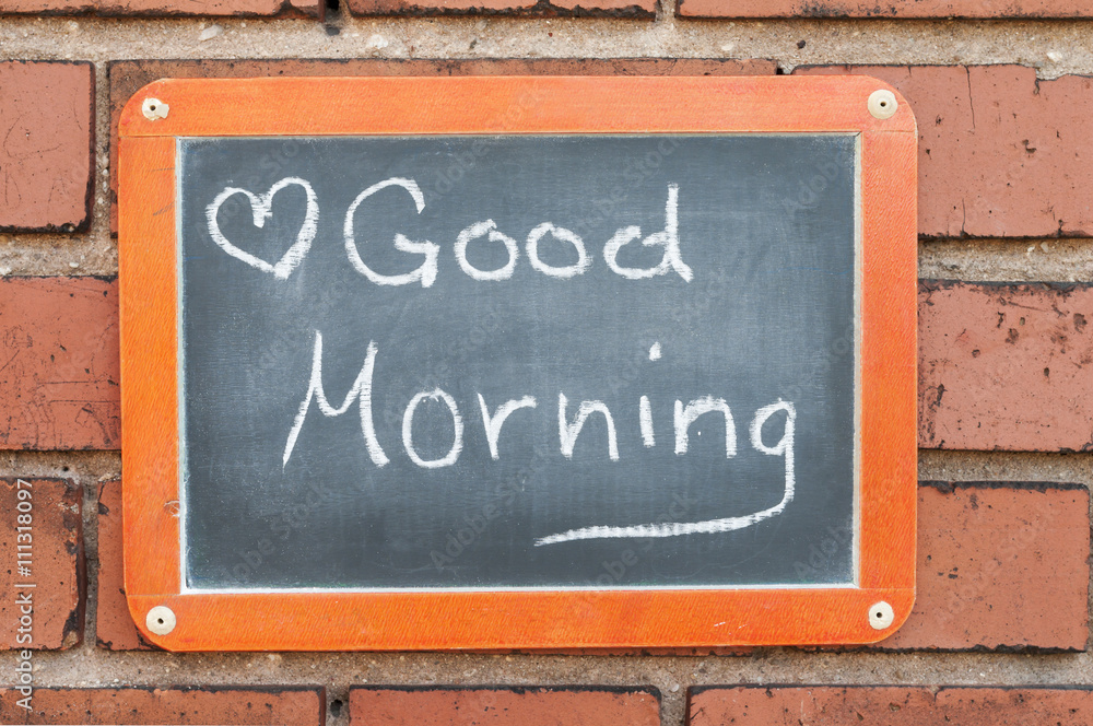 Fototapeta premium Tafel an einer Ziegelwand mit Text / Tafel an einer Ziegelwand mit Text Good Morning.