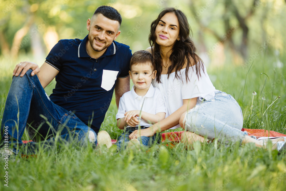 Ypung happy family spending their time in park on picnic Ypung happy family spending their time in park on picnic