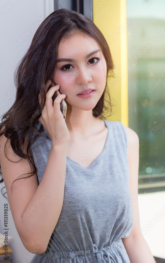 Business woman talking on the phone, smiling happily to light by Business woman talking on the phone, smiling happily to light by