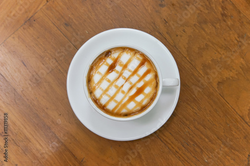 Принти на полотні Hot caramel macchiato on wooden table.