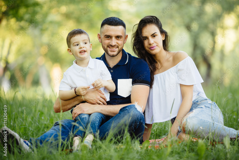 Ypung happy family spending their time in park on picnic Ypung happy family spending their time in park on picnic