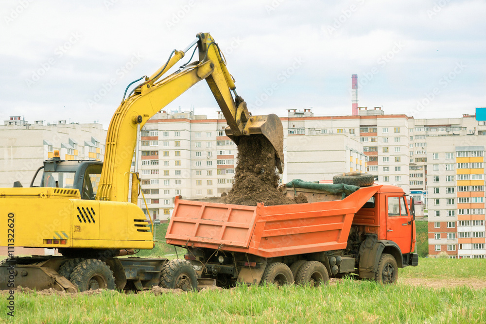 Excavator loads the ground in a dump truck