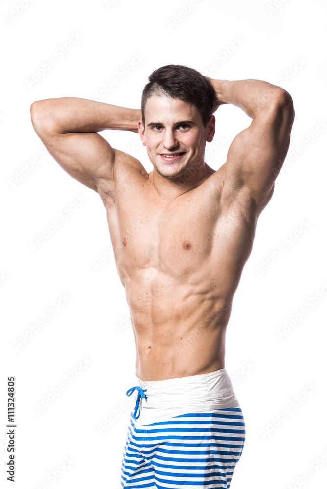 Portrait of a handsome young muscular man in swimwear with hands folded over his head isolated on white background