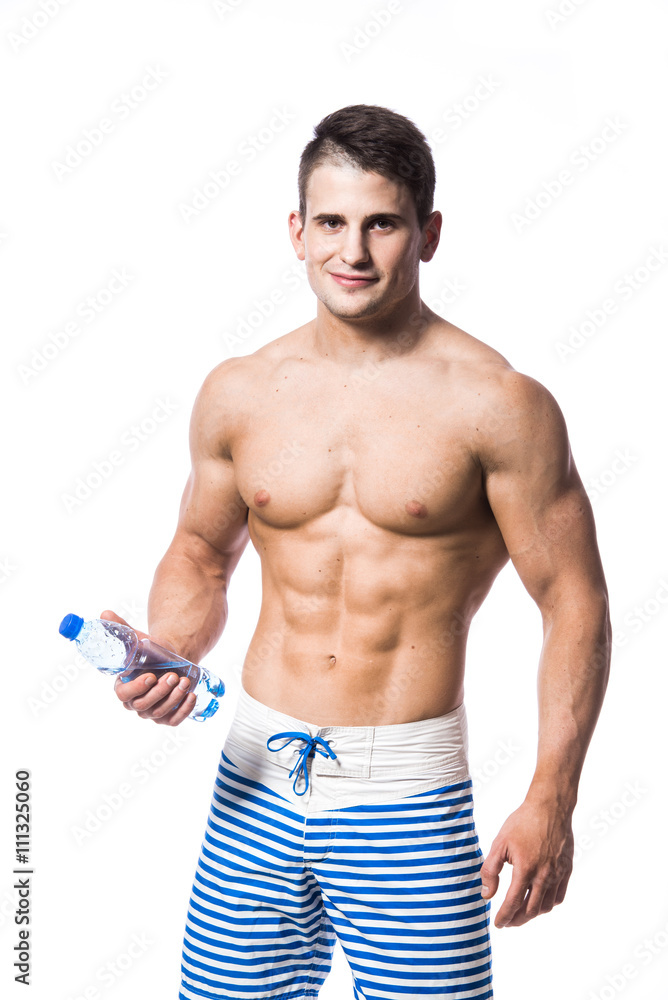 Young strong athlete on light background looking to the camera and smiling. Young strong athlete on light background looking to the camera and smiling.
