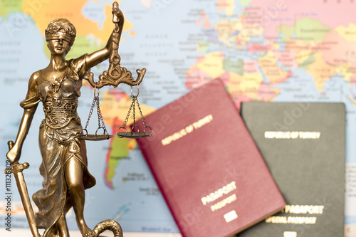 Law concept, statue, magnifying glass, passport and world map. Travel