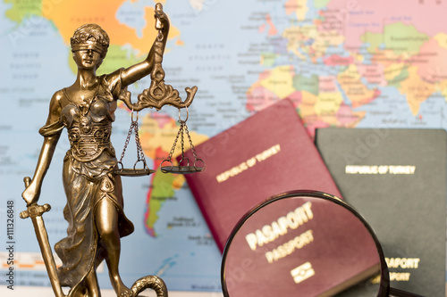 Law concept, statue, magnifying glass, passport and world map. Travel