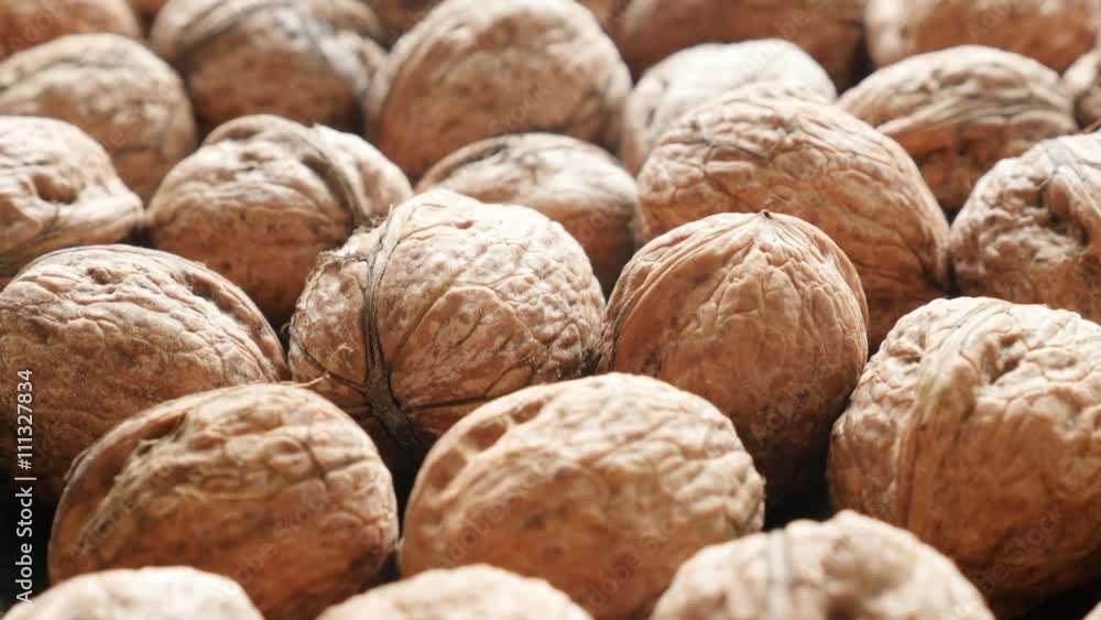 Hard shell walnut fruit pieces arranged on the table slow tilt 4K 2160p 30fps UltraHD video - Raw food background of seed of drupaceous nut 4K 3840X2160 UHD tilting footage Hard shell walnut fruit pieces arranged on the table slow tilt 4K 2160p 30fps UltraHD video - Raw food background of seed of drupaceous nut 4K 3840X2160 UHD tilting footage
