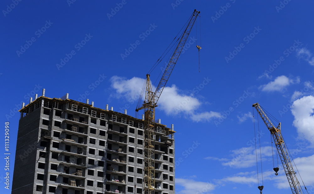 
build tall buildings for residents. standing next to a construction crane. blue sky