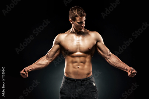 Stunning muscular man showing perfect abs, shoulders, biceps, tr