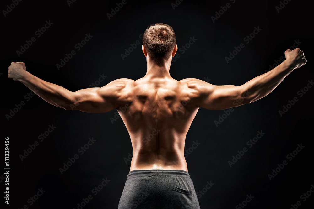 Naklejka premium Rear view of muscular young man showing back, biceps muscles