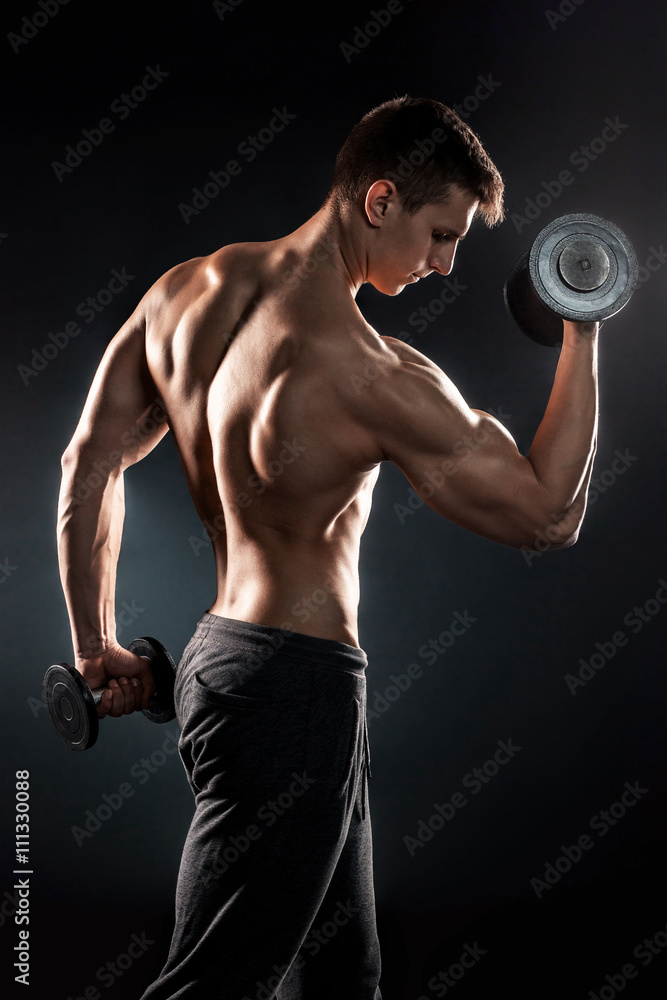 Man with naked torso and dumbbells on black background