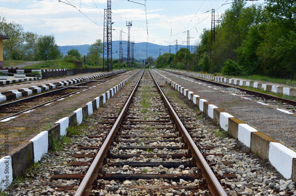 Reaching the horizon straight railways. Small railway station. Bulgarian countryside. 