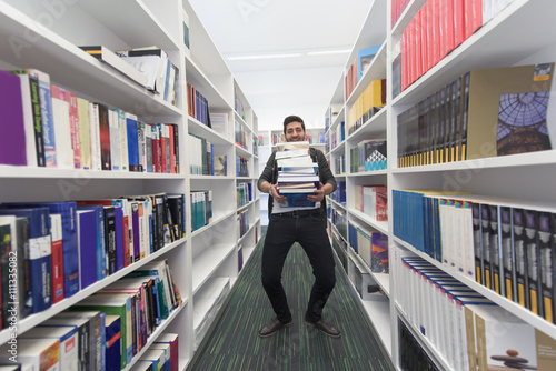 Wallpaper Mural Student holding lot of books in school library Torontodigital.ca