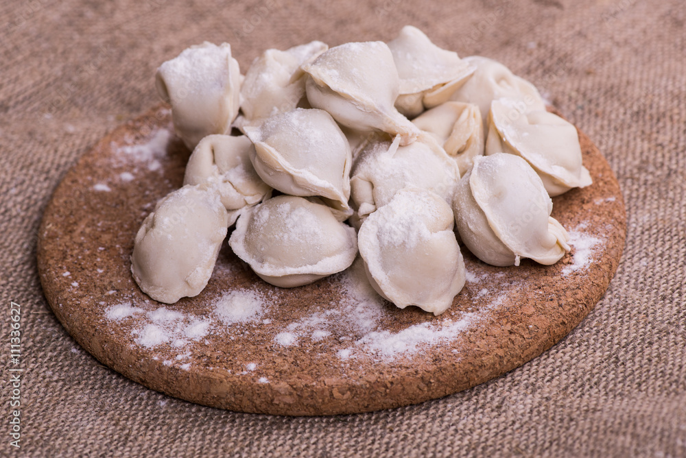Uncooked dumplings Pelmeni. Traditional Russian dish. Background from pelmeni laid out on a chopping board
