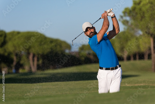 pro golfer hitting a sand bunker shot