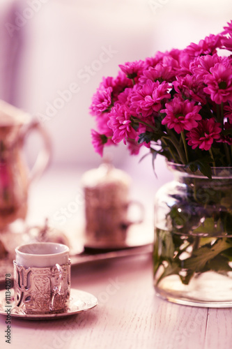 Beautiful flowers in vase on table in room