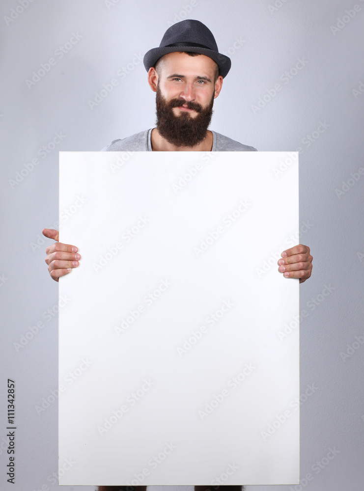 Portrait of young man in hat standing near blank, isolated on white background Portrait of young man in hat standing near blank, isolated on white background