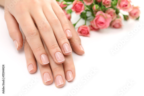 Woman hands with beautiful manicure and roses isolated on white background