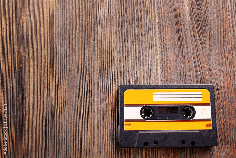 Fototapeta premium Old audio cassette on wooden background