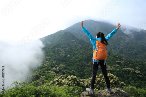 young woman backpacker hiking at forest mountain top