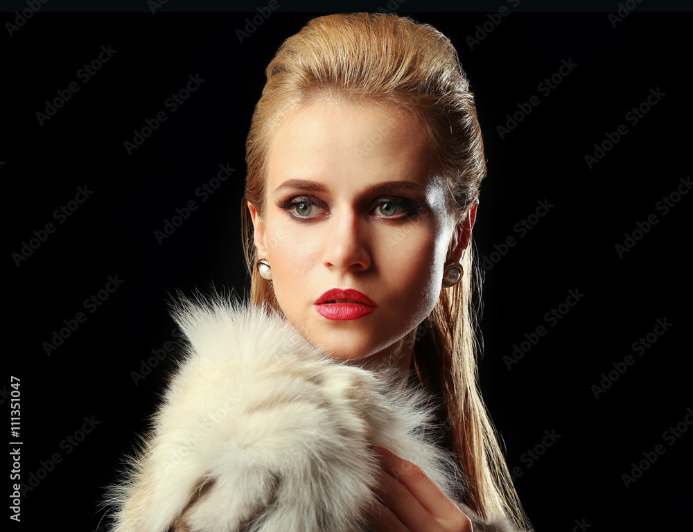 Beautiful young woman with luxury fur on dark background with blue light Beautiful young woman with luxury fur on dark background with blue light
