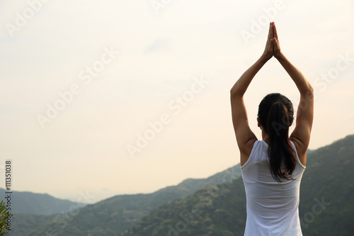 young fitness yoga woman at mountain peak..