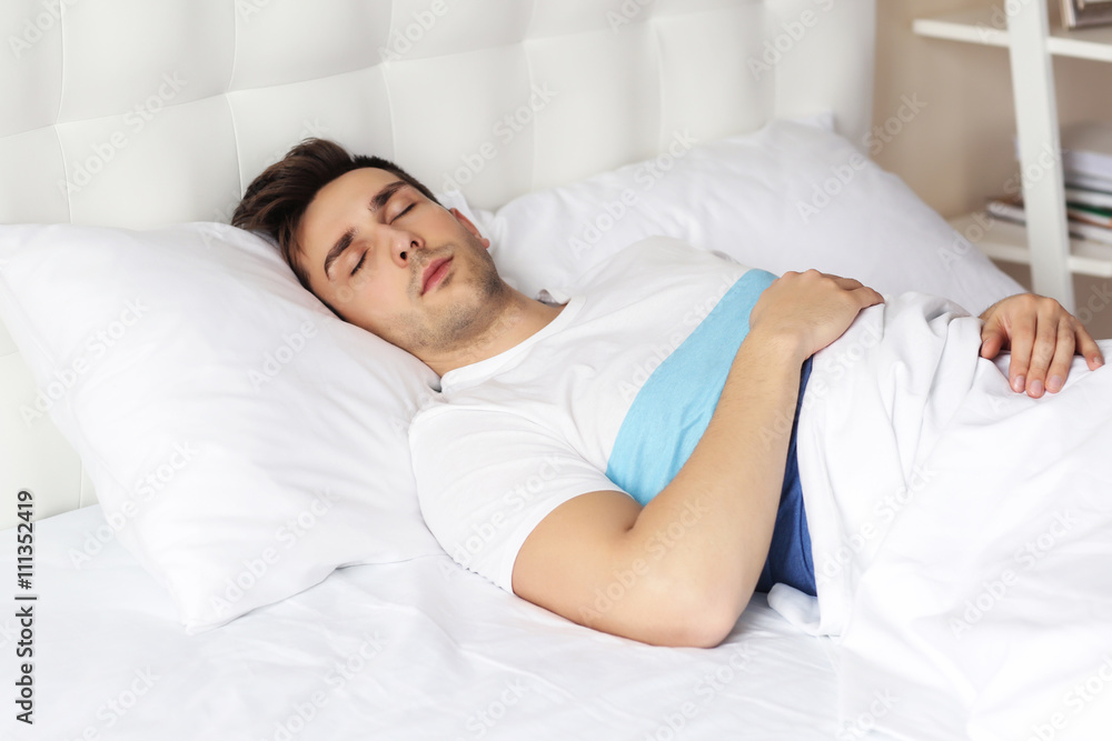 Young man sleeping on comfortable bed Young man sleeping on comfortable bed