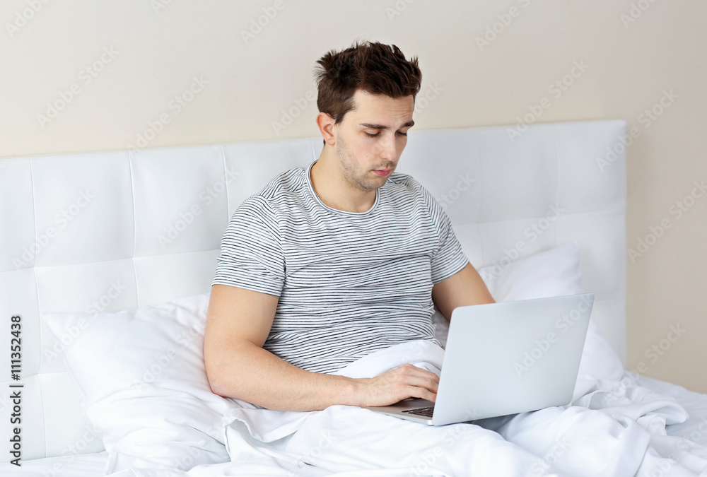 Man sitting in bed with his laptop Man sitting in bed with his laptop