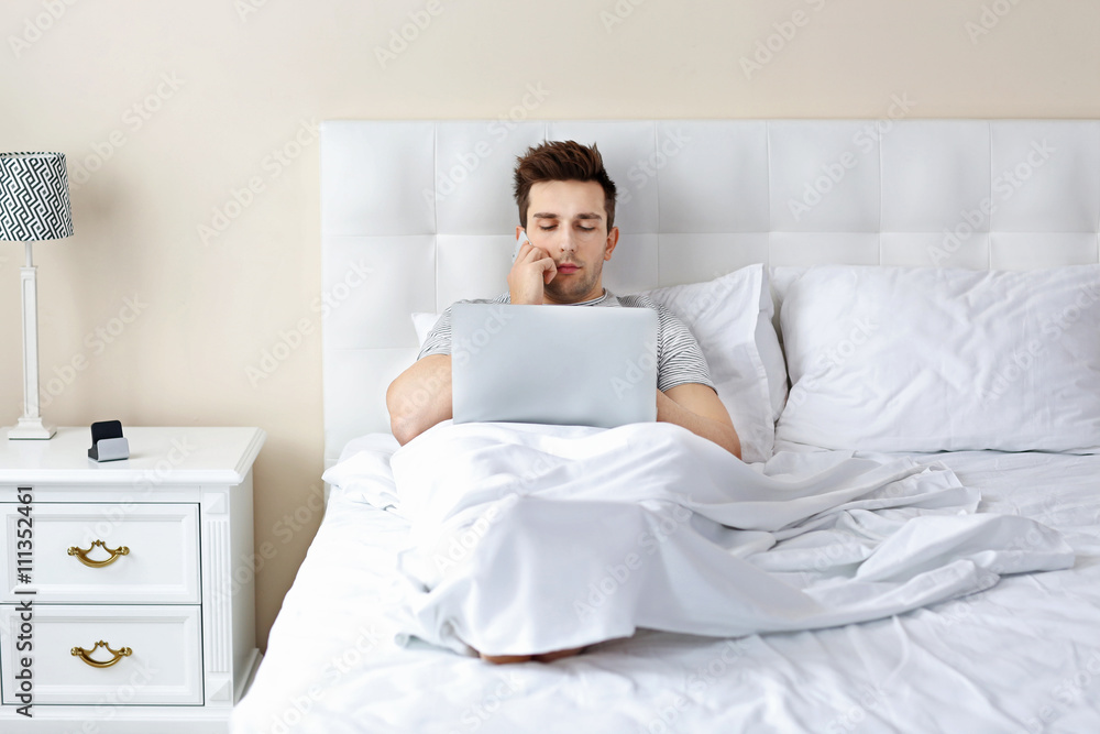 Man lying in bed with his laptop Man lying in bed with his laptop