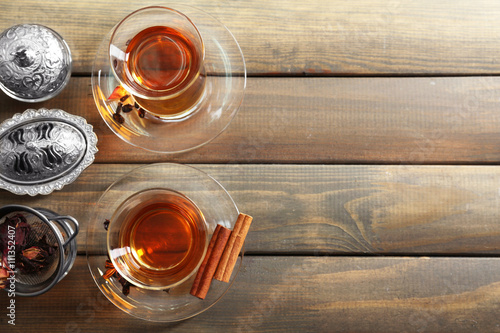 Glass cups of tea on wooden background