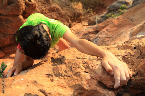 young woman rock climber climbing at mountain rock