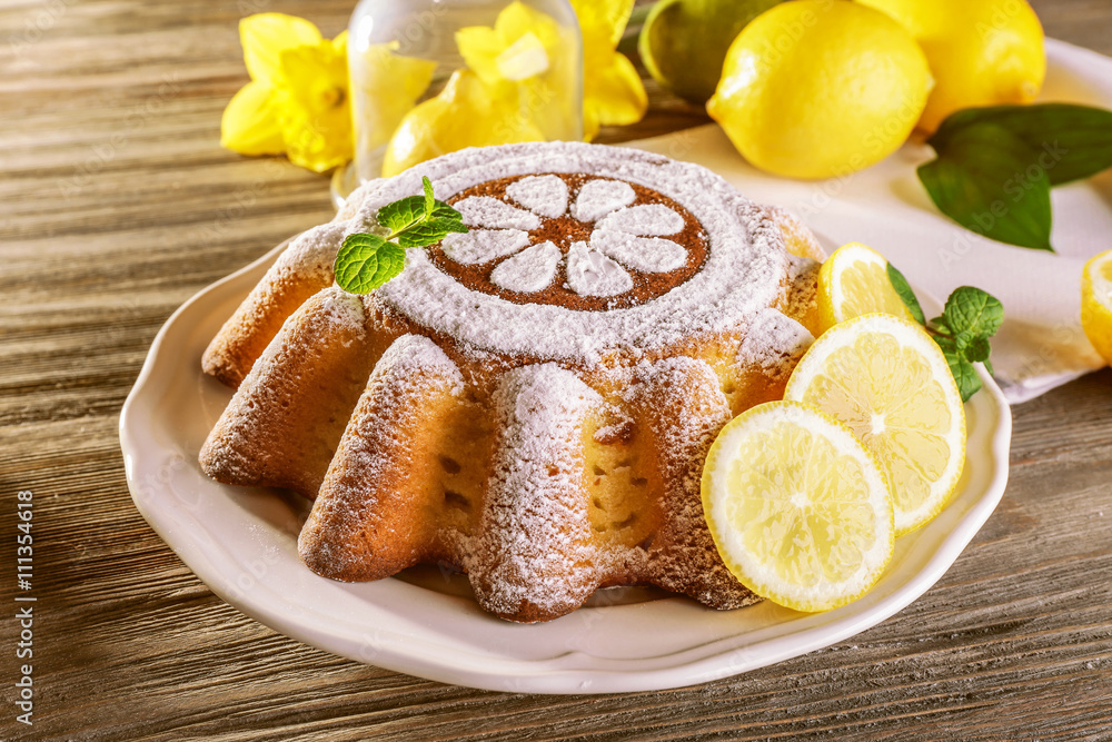 Delicious citrus cake on a white plate with lemons Delicious citrus cake on a white plate with lemons