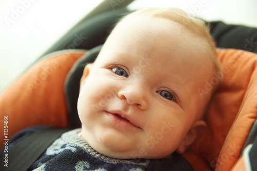 Adorable baby boy sitting i...