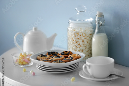 Delicious cookies and white tableware on a wooden table.