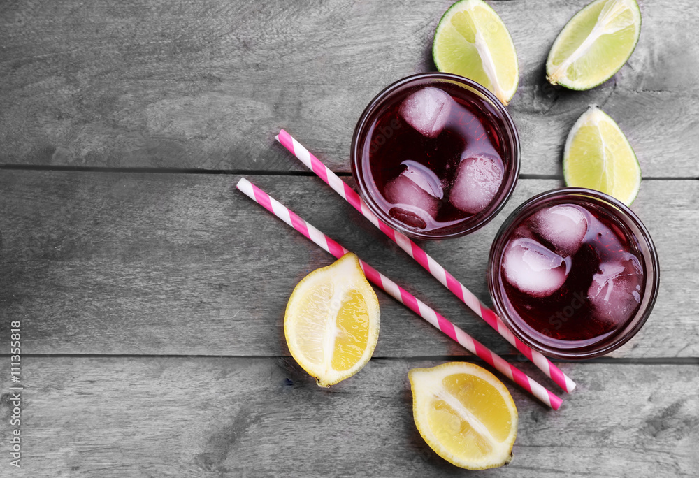 Glasses of red soda water and sliced lemon on wooden table, top view Glasses of red soda water and sliced lemon on wooden table, top view