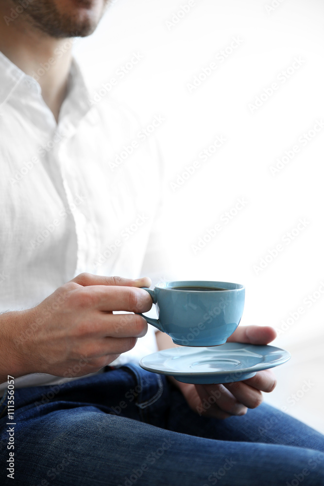 Man holding blue cup of coffee, close up Man holding blue cup of coffee, close up