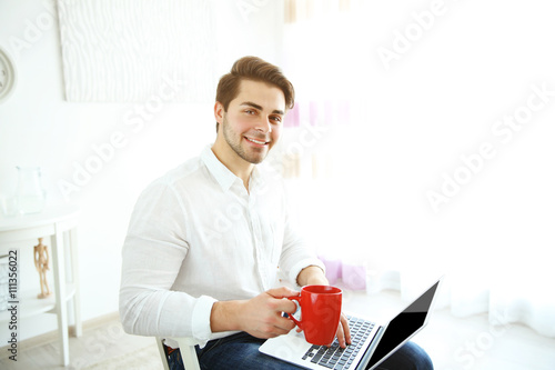 Handsome man holding laptop...