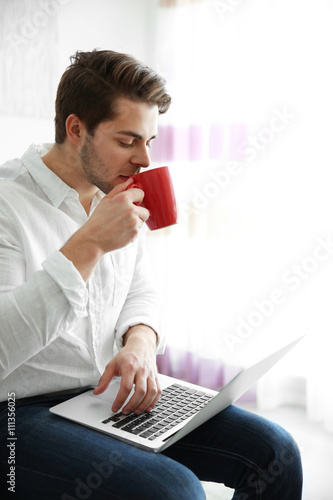 Handsome man holding laptop...