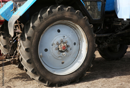 Wheel of a blue tractor, close up © Africa Studio