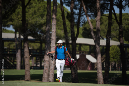 golf player walking and carrying bag