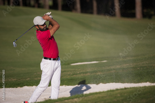 golfer hitting a sand bunker shot