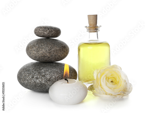 Spa still life with pebbles, oil and candle isolated on white