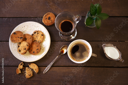 Cup of coffee with cookies on wooden table