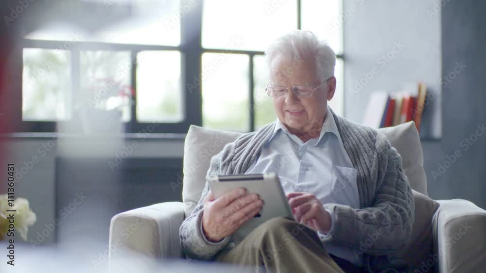 old man is using tablet computer at home old man is using tablet computer at home