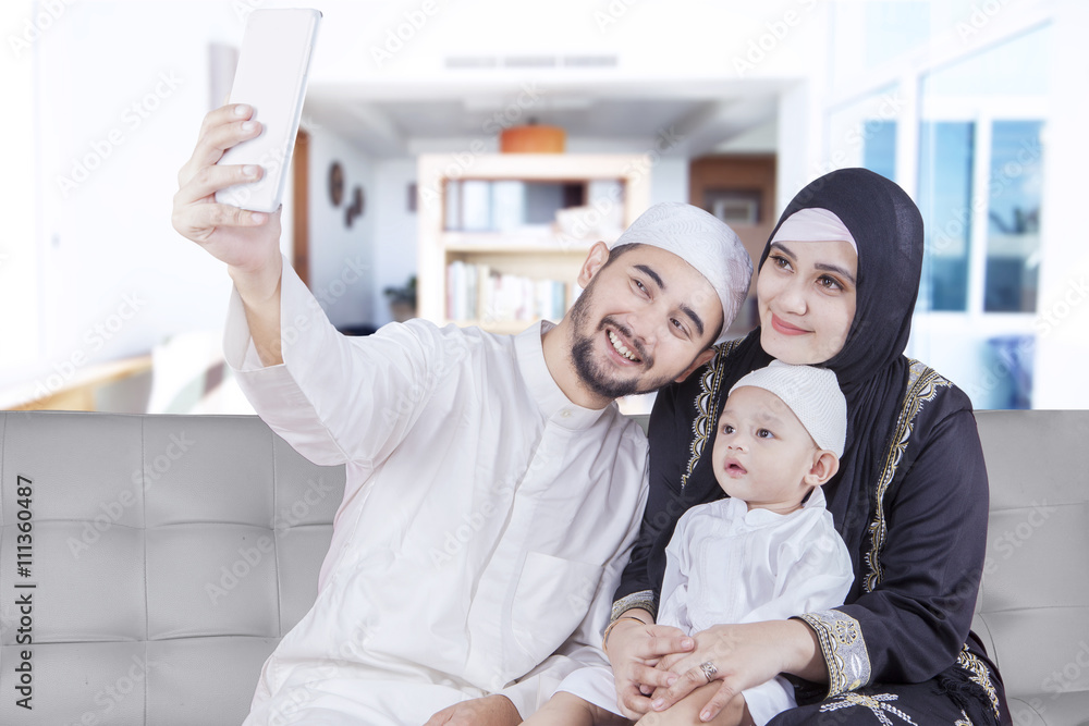 Fototapeta premium Arabic parents and their son taking selfie photo