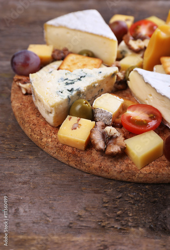 Different kinds of cheese on wooden background