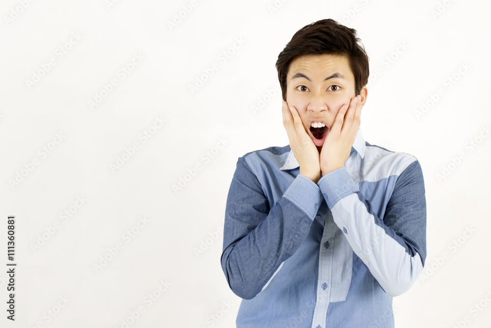 Asian young man surprised, shocked, scared, with hands on his cheeks Asian young man surprised, shocked, scared, with hands on his cheeks