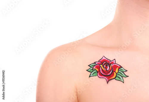 Flower body art on female right shoulder over white background