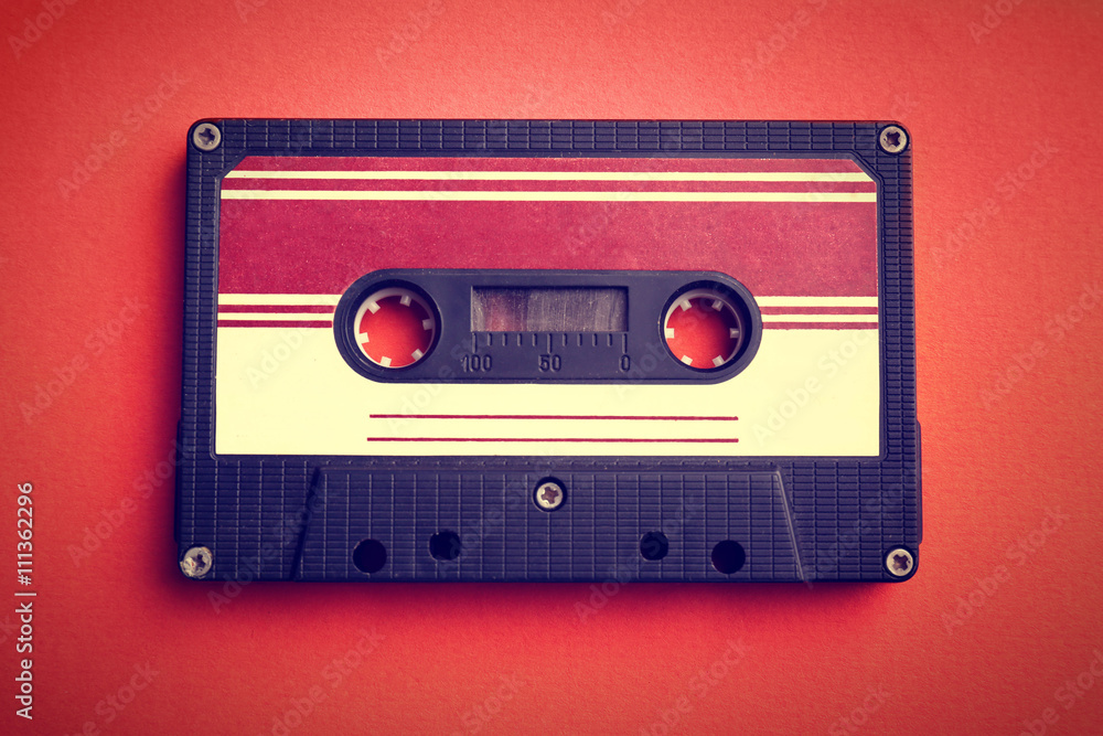 Naklejka premium Old audio cassette on red background