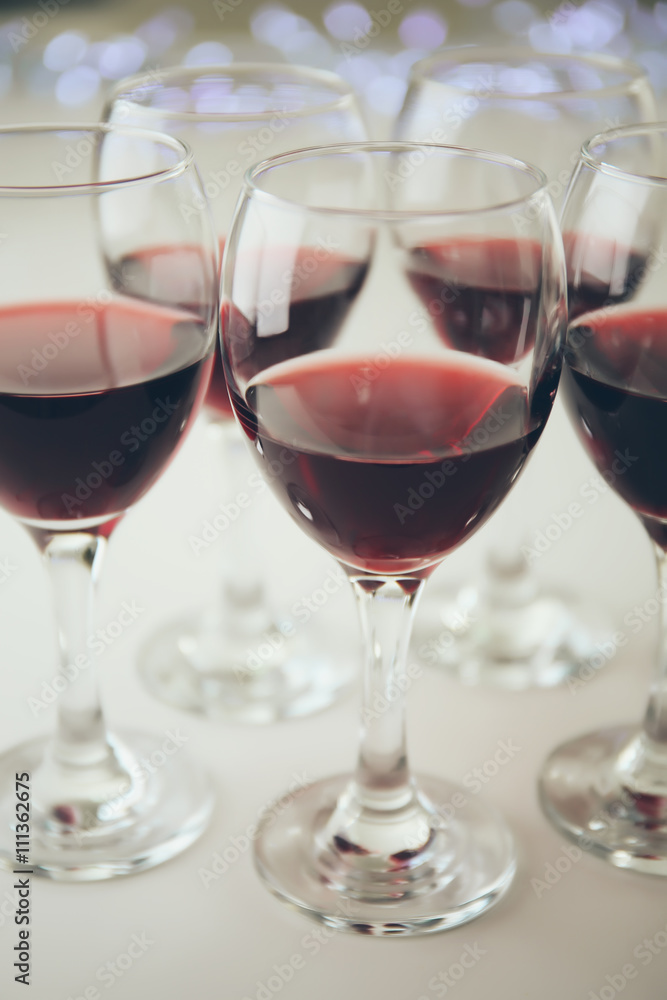 Glasses of red wine on white table closeup